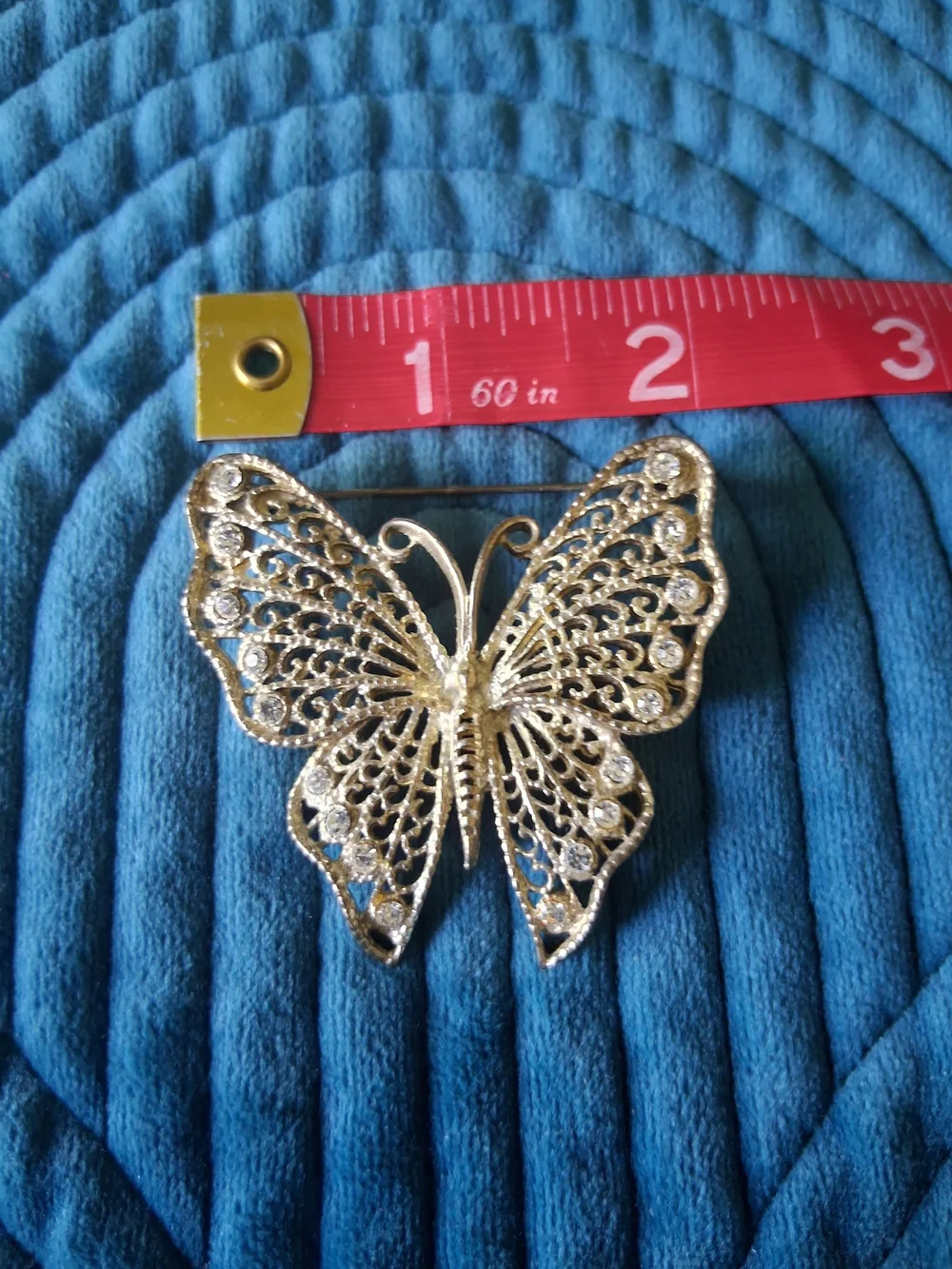 Vintage silver-tone filigree butterfly brooch adorned with rhinestones
